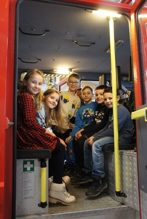 Gruppenbild der Grundschüler in einem Feuerwehrauto